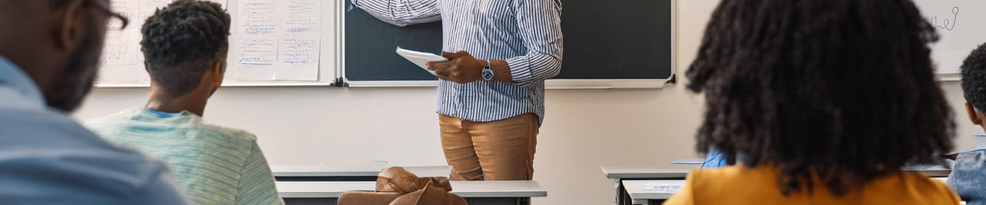 A group of adult students listening to a teacher.