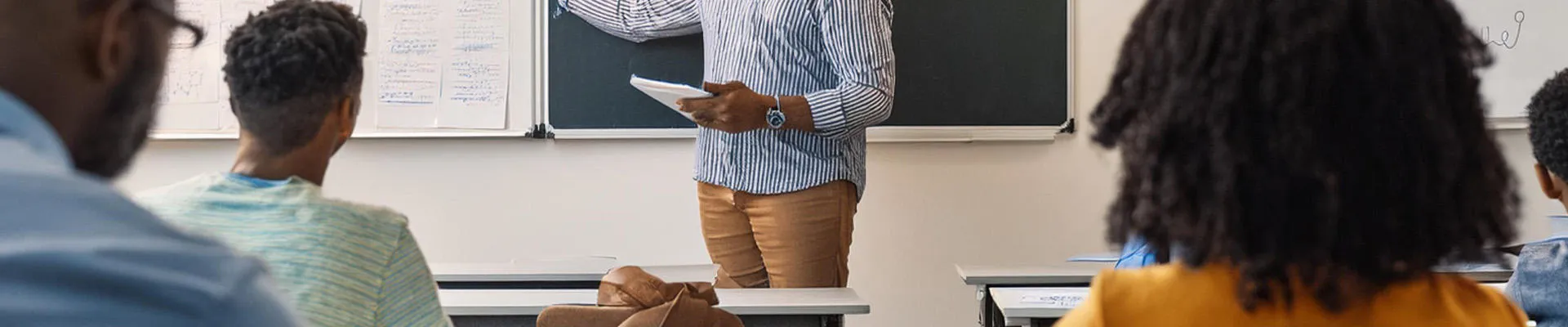 A group of adult students listening to a teacher.