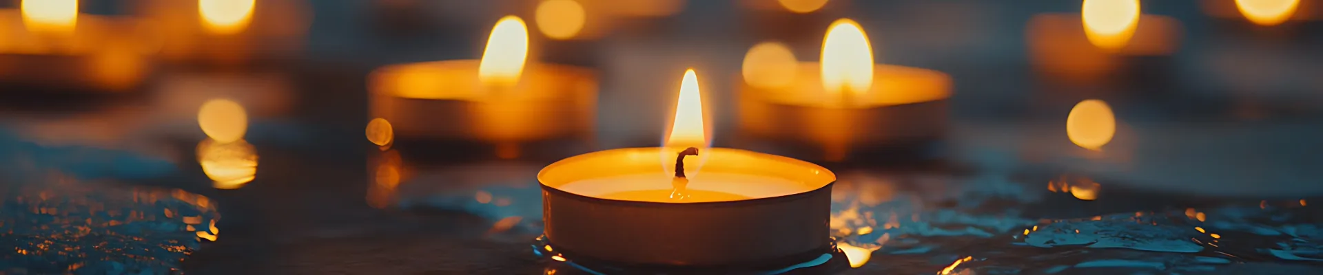 Lit tea light candles against a dark background