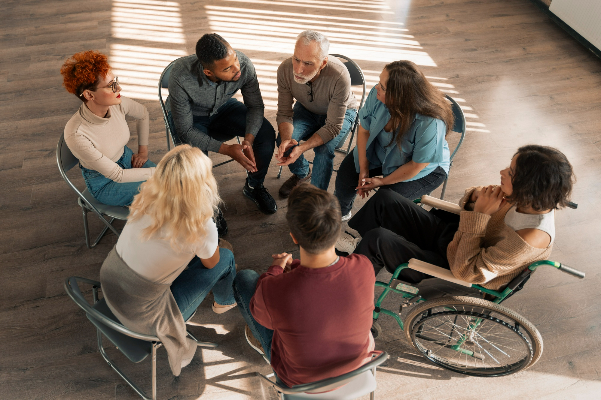 Group of diverse individuals sat in a circle having a discussion