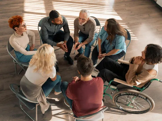 Group of diverse individuals sat in a circle having a discussion