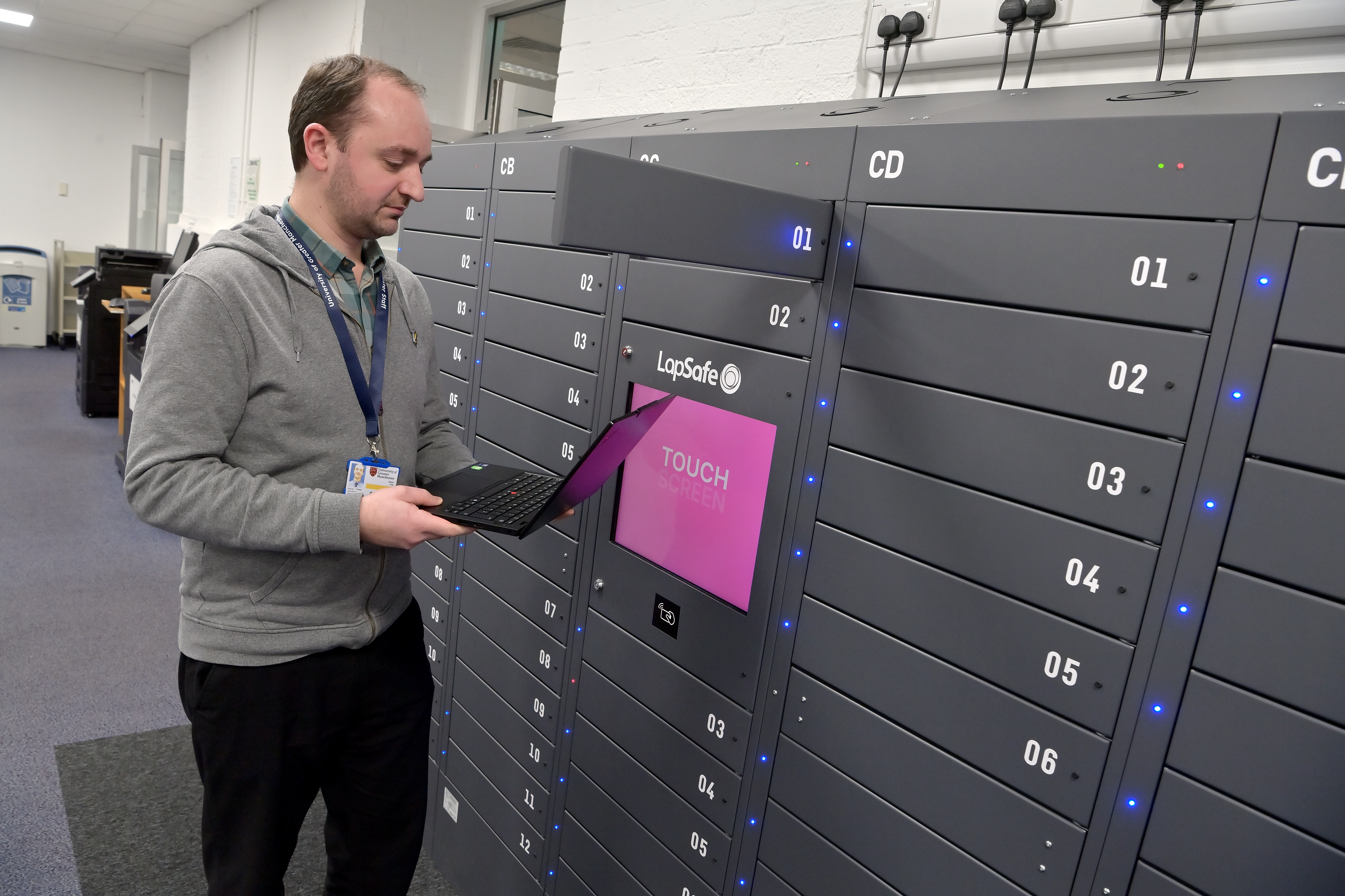 Person borrowing a laptop from self-service laptop loan cabinets