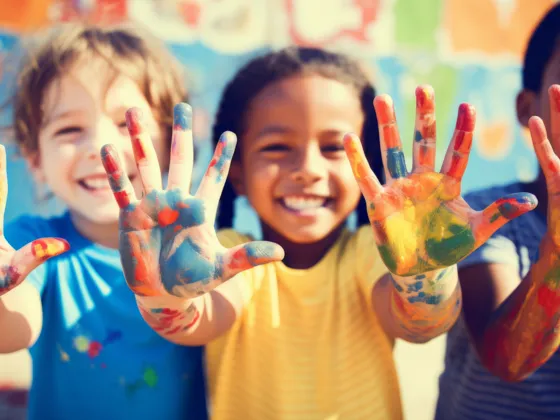 Happy children with painted hands.