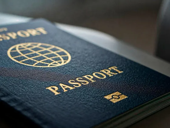 A front cover of a blue passport resting on a desk.