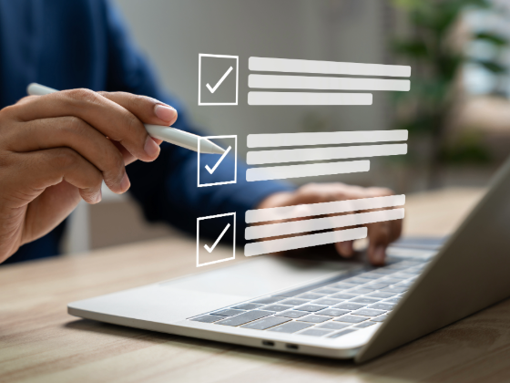 A virtual tick list floating above a laptop screen.