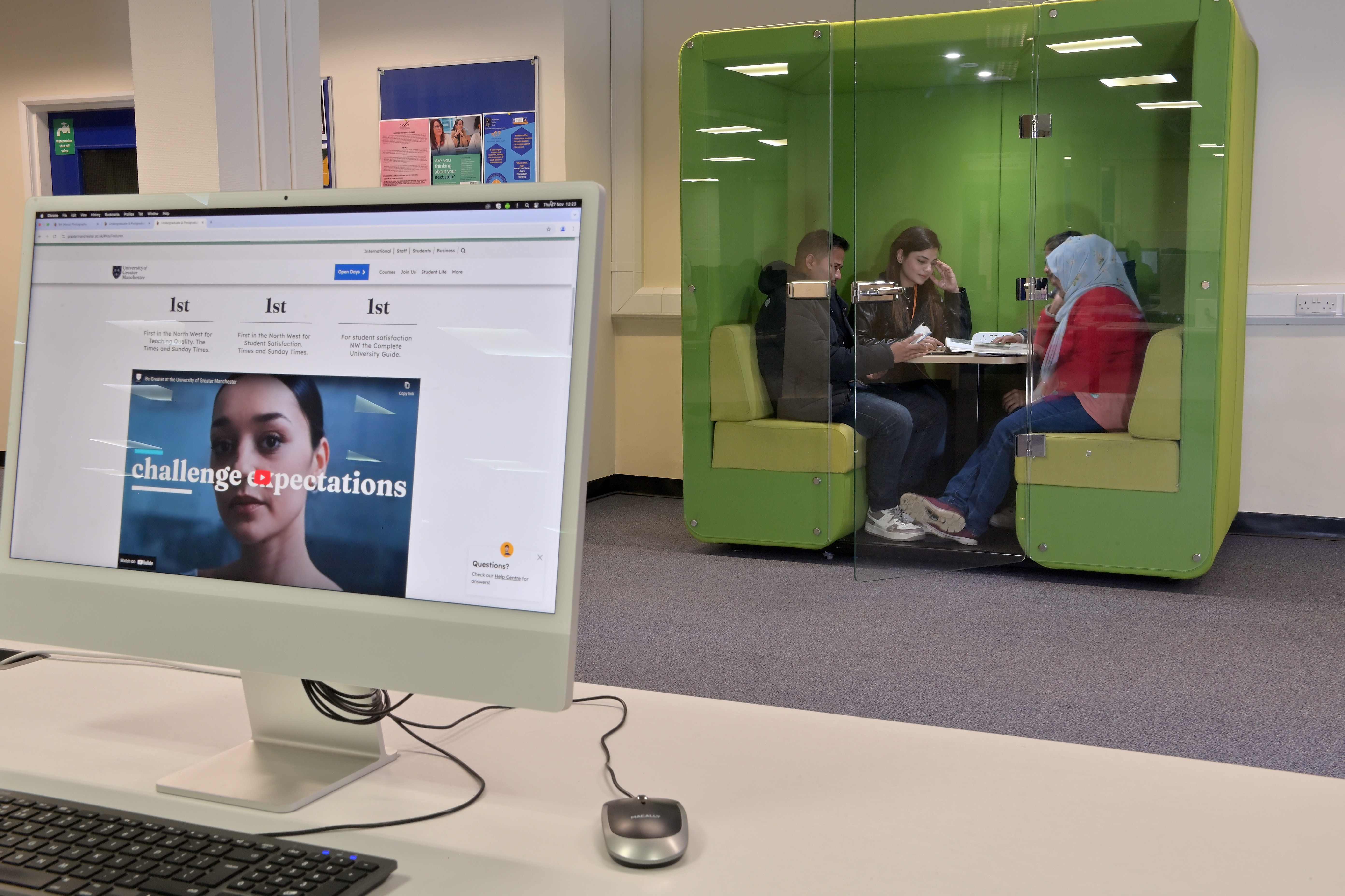 A modern library with study pod occupied by students studying as a group.