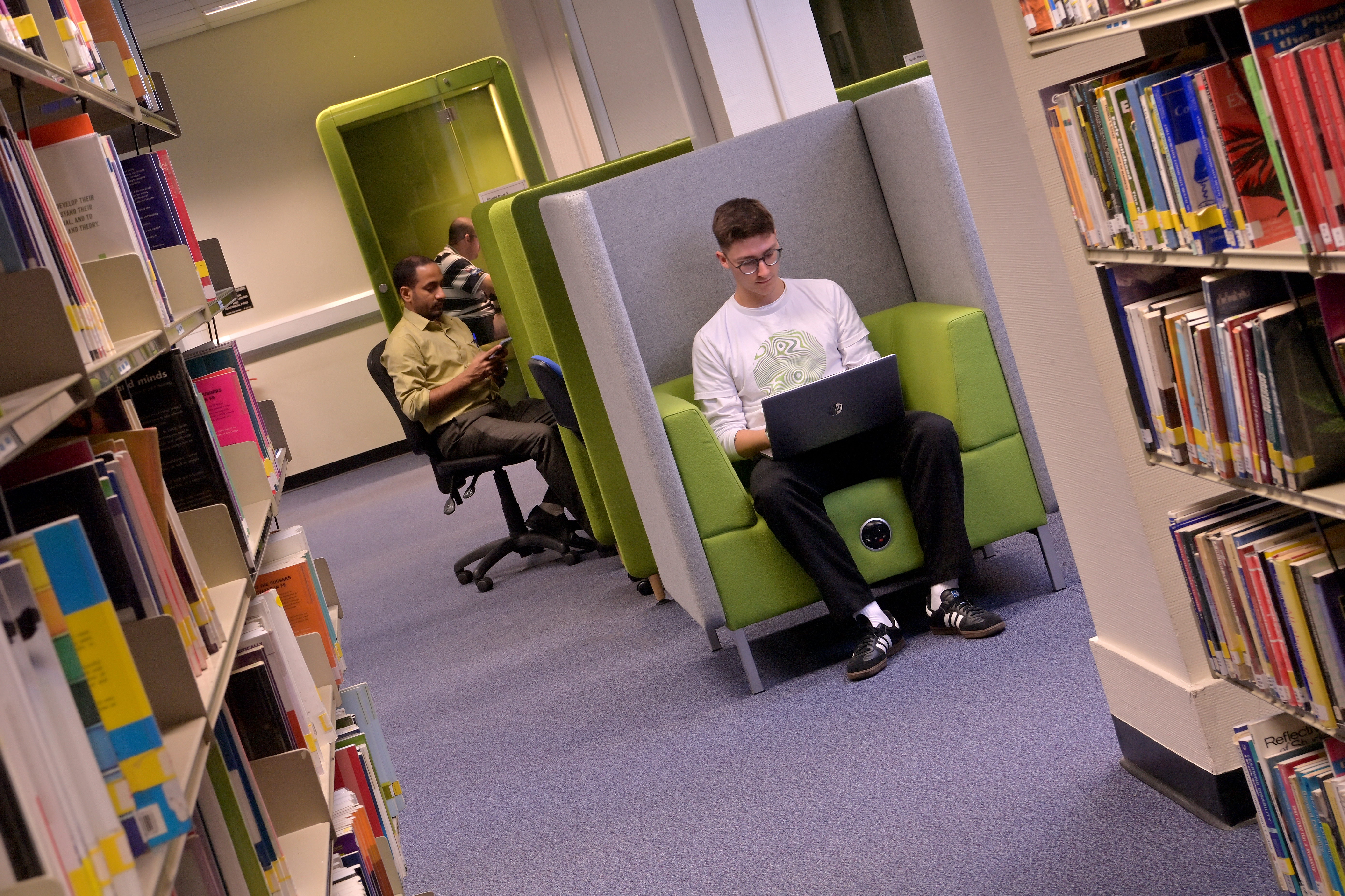 Student sat in a study pod using a laptop computer.