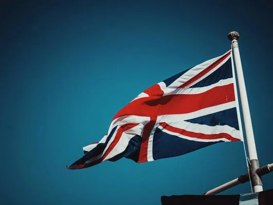Union flag flying from flag pole against a clear blue sky